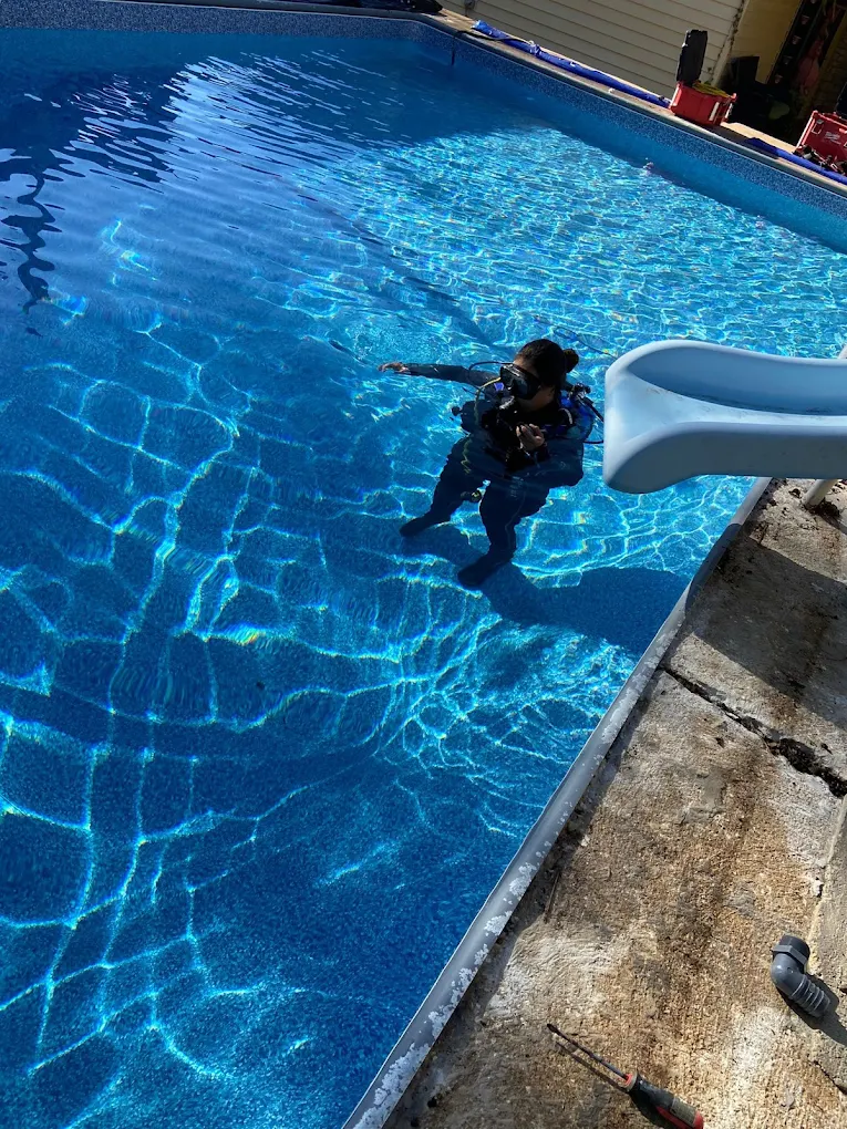 Gold Star diver inspecting a pool for leaks underwater